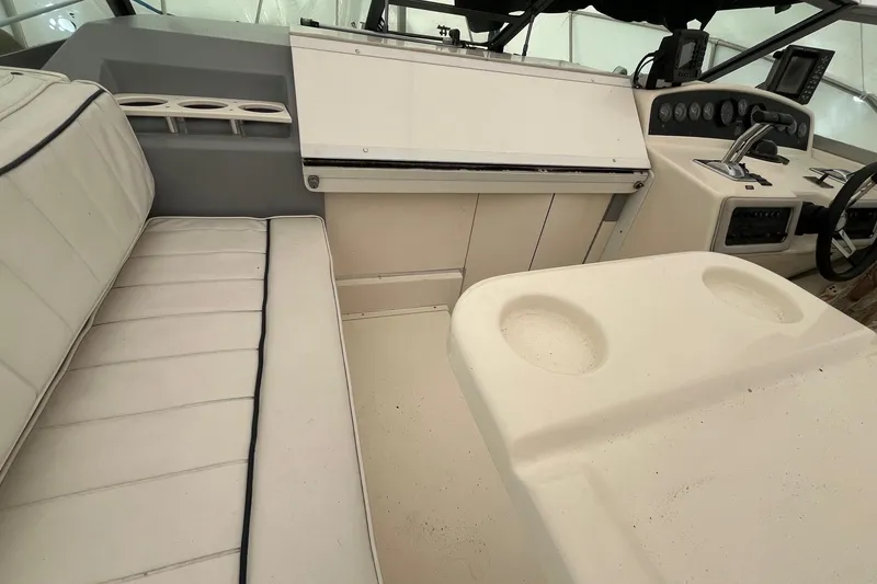 Slide: The Image of Interior of a 1994 Sea Ray 310 Amberjack boat, featuring white seating and control panel. - 10