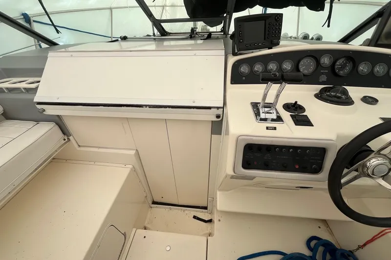 Slide: The Image of 1994 Sea Ray 310 Amberjack cockpit with steering wheel, control panel, and navigation equipment. - 11