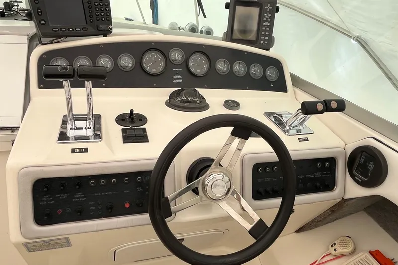 Slide: The Image of Control panel of a 1994 Sea Ray 310 Amberjack boat with steering wheel and gauges. - 12