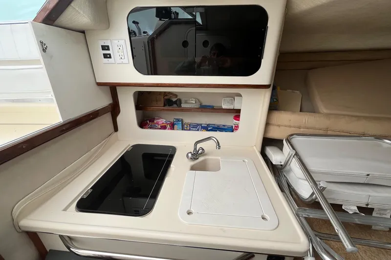 Slide: The Image of 1994 Sea Ray 310 Amberjack boat interior with kitchenette, sink, and storage shelves. - 20