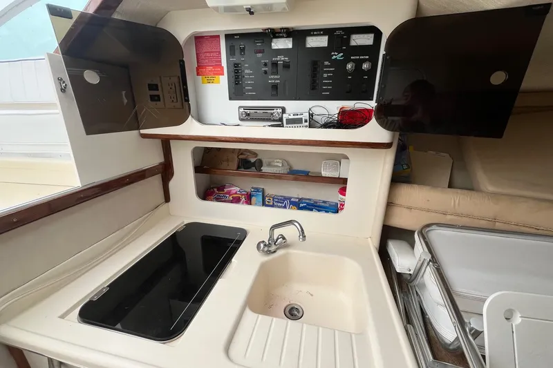 Slide: The Image of Interior of 1994 Sea Ray 310 Amberjack boat with kitchenette and control panel. - 21