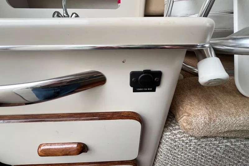 Slide: The Image of 1994 Sea Ray 310 Amberjack interior detail with 12V DC outlet and wooden accents. - 23