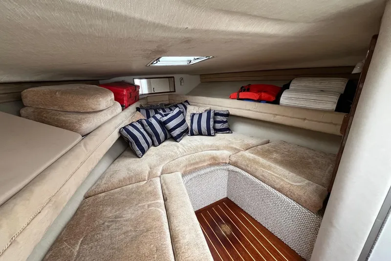 Slide: The Image of 1994 Sea Ray 310 Amberjack cabin interior with cushions and striped pillows. - 24
