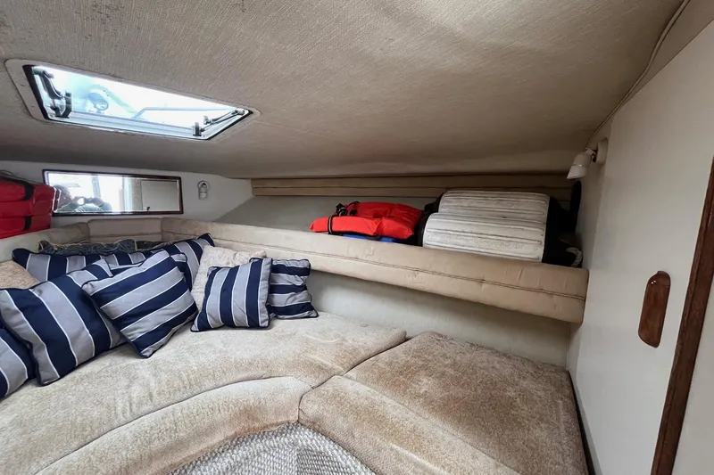 Slide: The Image of Cozy cabin interior of 1994 Sea Ray 310 Amberjack with striped pillows and storage. - 25