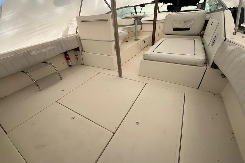 Slide: The Image of 1994 Sea Ray 310 Amberjack boat interior with white seating and spacious deck area. - 3