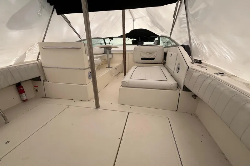 Slide: The Image of 1994 Sea Ray 310 Amberjack interior with white seating and canopy, showcasing spacious design. - 4