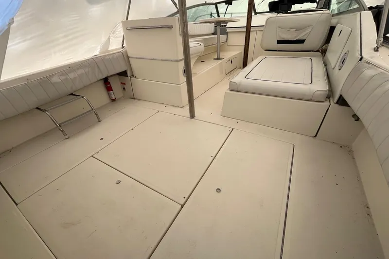 Slide: The Image of 1994 Sea Ray 310 Amberjack boat interior with white seating and spacious deck area. - 5