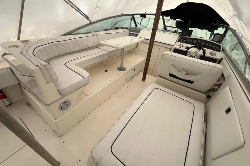 Slide: The Image of 1994 Sea Ray 310 Amberjack boat interior with white seating and helm station. - 6