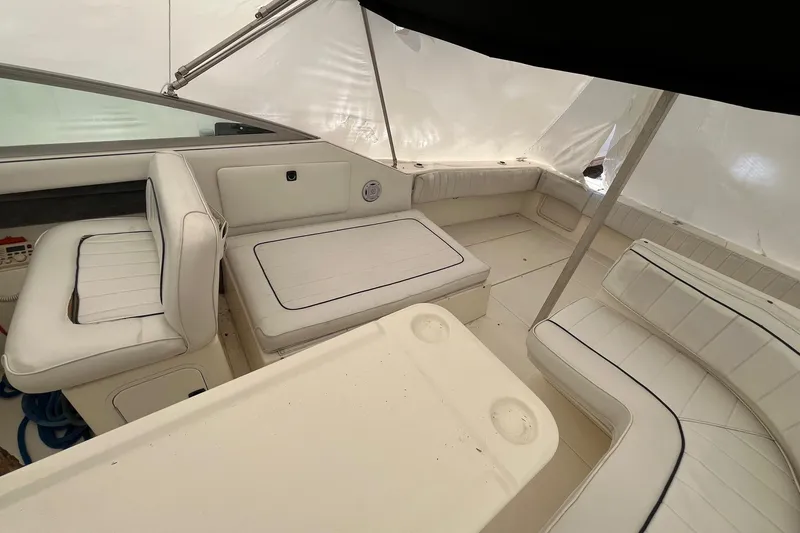 Slide: The Image of Interior of 1994 Sea Ray 310 Amberjack boat with white seating and table. - 9