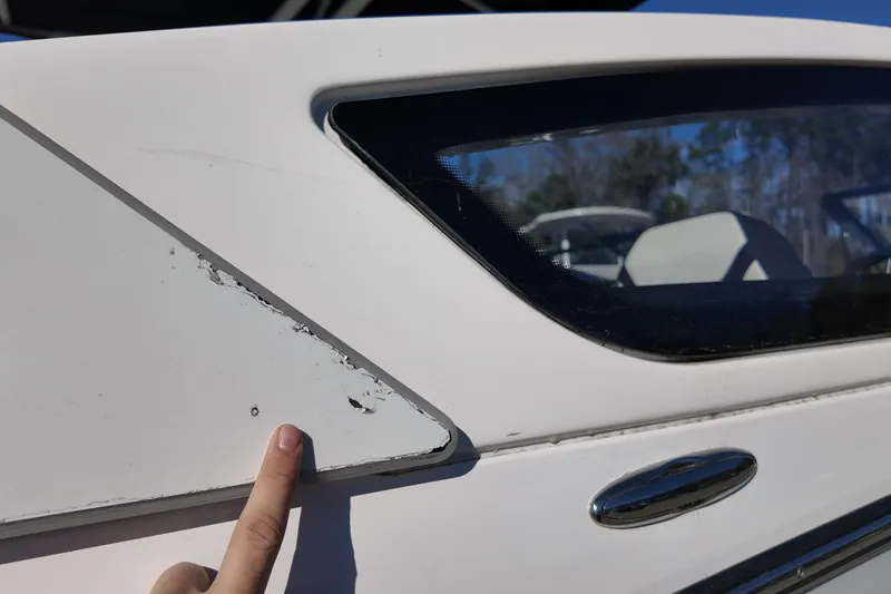 Slide: The Image of 2024 Yamaha Boats 275SE with visible paint damage near window. - 20