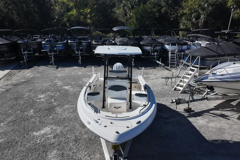 Slide: The Image of 2021 Robalo R222 Center Console boat in a storage yard, surrounded by other boats. - 11