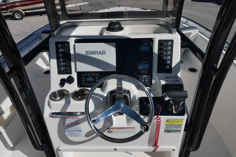 Slide: The Image of 2021 Robalo R222 Center Console boat dashboard with Simrad display and steering wheel. - 8