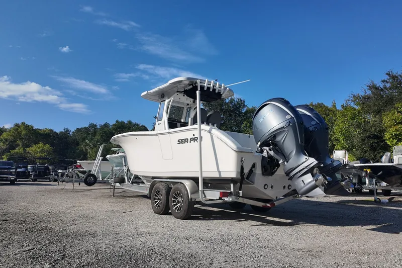 Slide: The Image of 2025 Sea Pro 262 Offshore boat on trailer, parked outdoors under clear blue sky. - 4