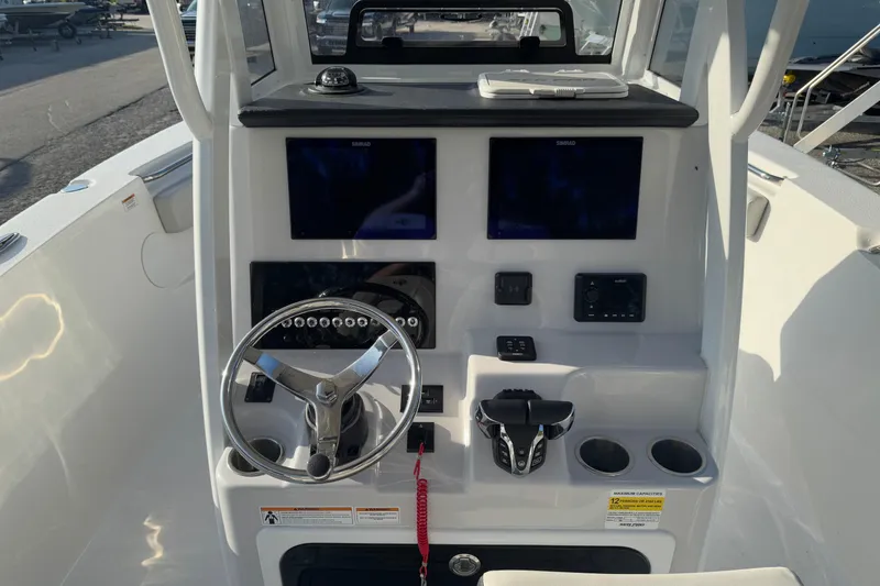Slide: The Image of 2025 Sea Pro 262 Offshore boat dashboard with dual screens and steering wheel. - 9