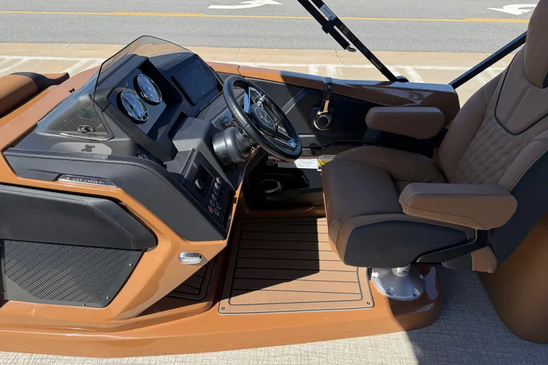Slide: The Image of 2026 Avalon Catalina Quad Lounge boat cockpit with brown seating and modern dashboard controls. - 17
