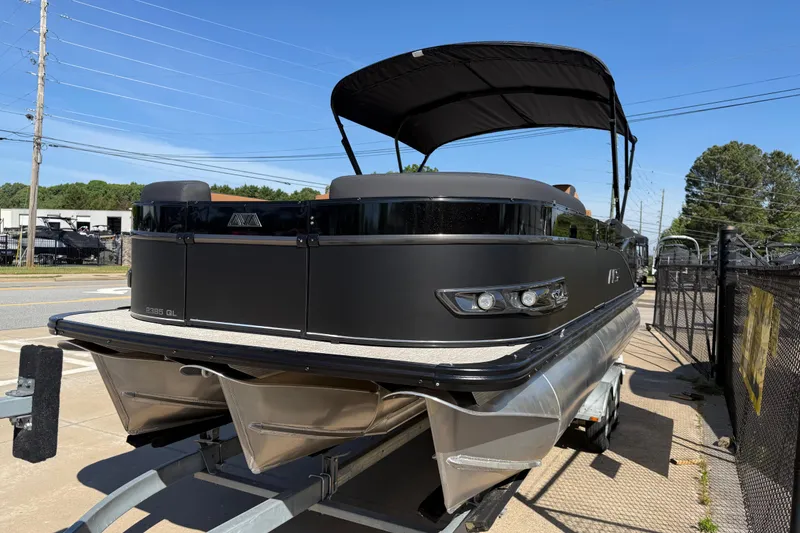 Slide: The Image of 2026 Avalon Catalina Quad Lounge 23' pontoon boat on trailer, black exterior, sunny day. - 2