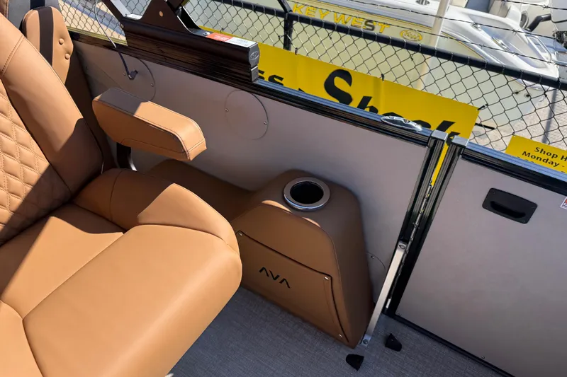 Slide: The Image of Luxurious seating in 2026 Avalon Catalina Quad Lounge boat, featuring tan upholstery and cup holder. - 27