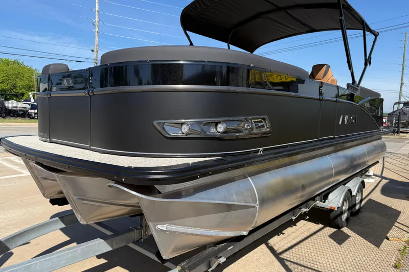 Slide: The Image of 2026 Avalon Catalina Quad Lounge 23' pontoon boat on trailer, sleek black design. - 3