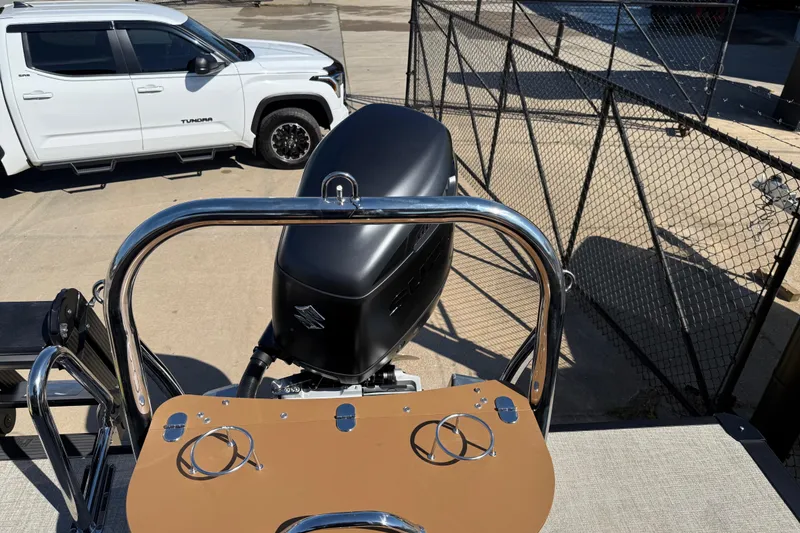 Slide: The Image of 2026 Avalon Catalina Quad Lounge boat with motor, parked near a white truck. - 39