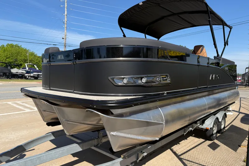 Slide: The Image of 2026 Avalon Catalina Quad Lounge 23' pontoon boat on trailer, sleek black design. - 64