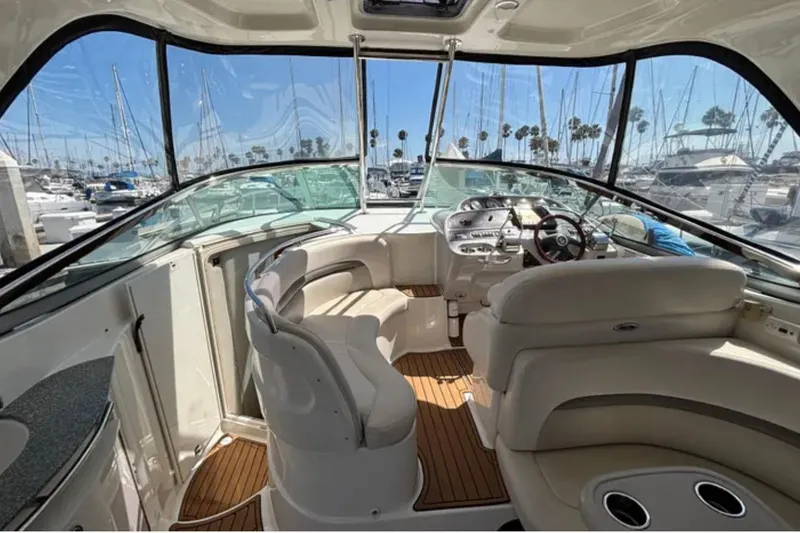 Slide: The Image of 2007 Chaparral Signature 350 boat interior with plush seating and modern dashboard in marina setting. - 4