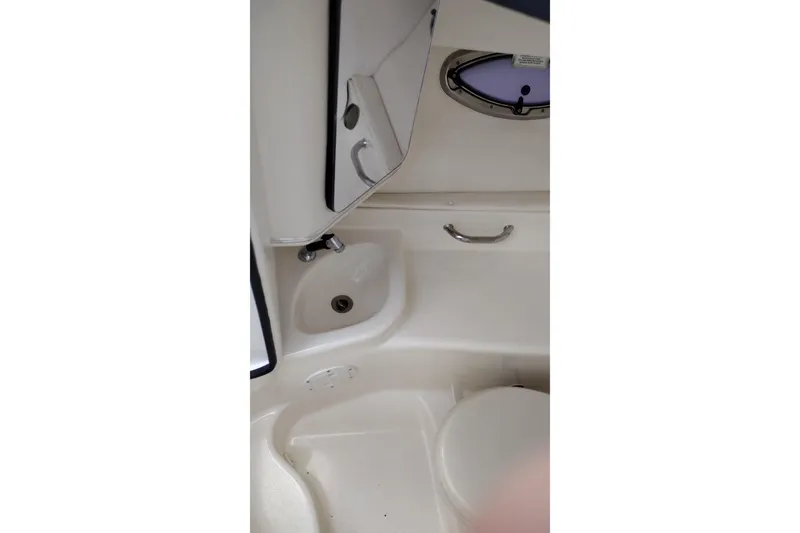 Slide: The Image of Interior of 2013 Sea Ray 300 SLX boat showing compact bathroom with sink and toilet. - 19
