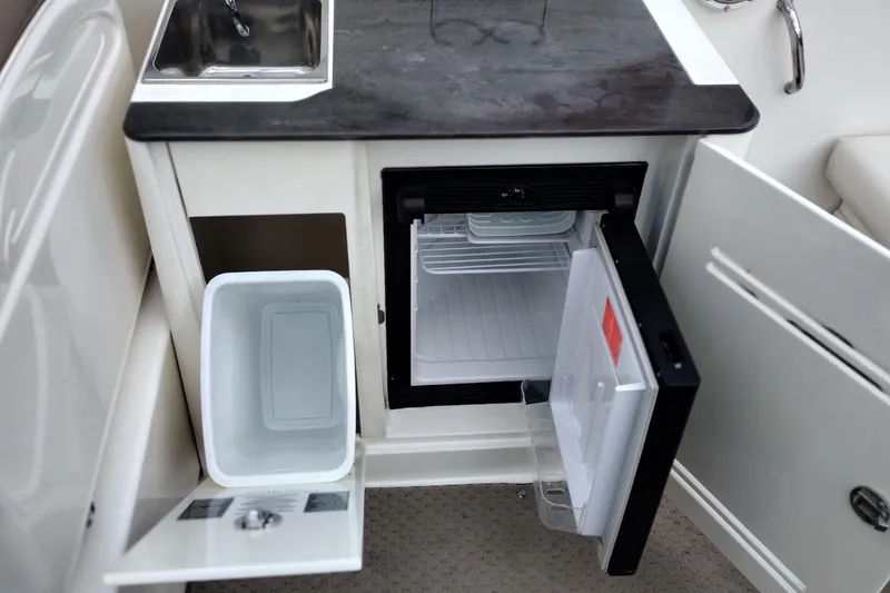 Slide: The Image of 2013 Sea Ray 300 SLX boat kitchenette with sink, mini fridge, and storage. - 28