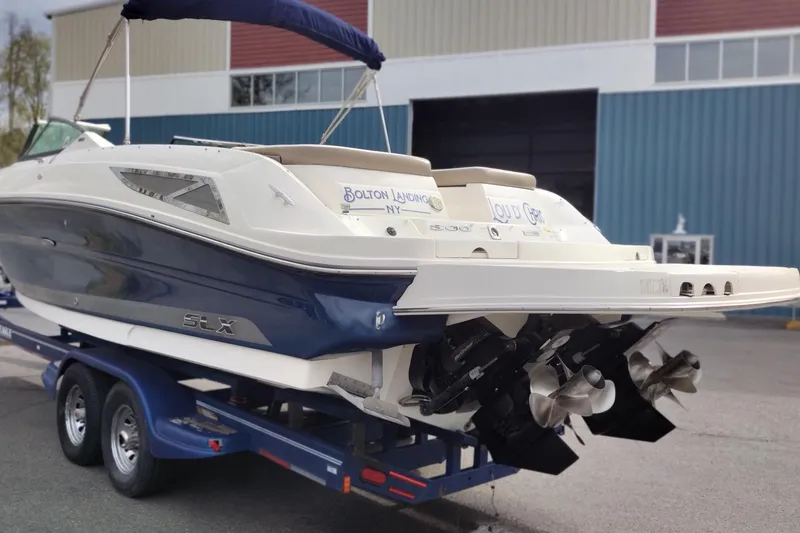 Slide: The Image of 2013 Sea Ray 300 SLX boat on trailer, displayed outdoors near a building. - 3