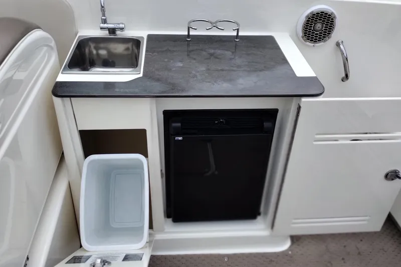 Slide: The Image of 2013 Sea Ray 300 SLX boat kitchenette with sink, countertop, and mini fridge. - 42