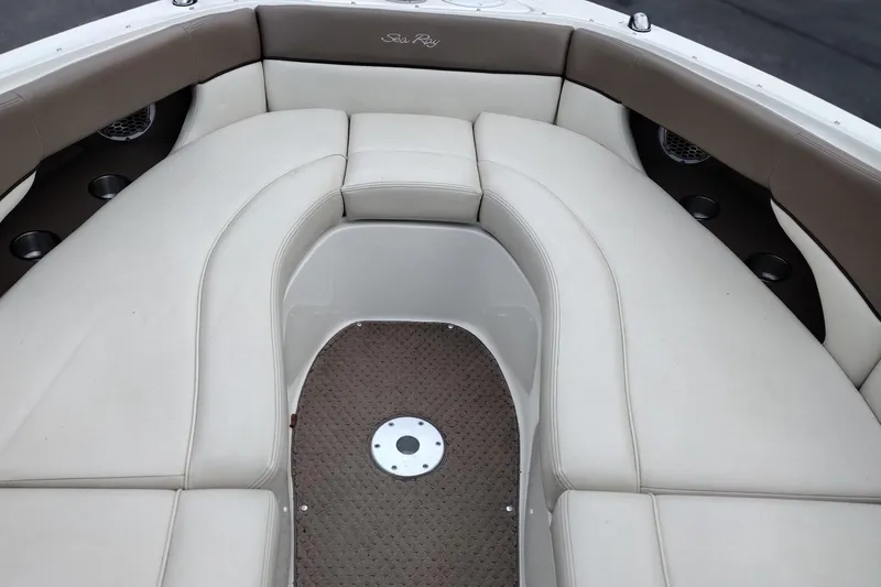 Slide: The Image of Interior seating of a 2013 Sea Ray 300 SLX boat, featuring beige upholstery and cup holders. - 43