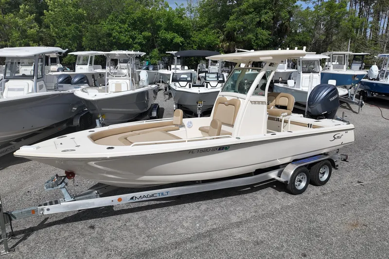 The Image of 2021 Scout 251 XSS boat on trailer, surrounded by other boats in a marina. - 0