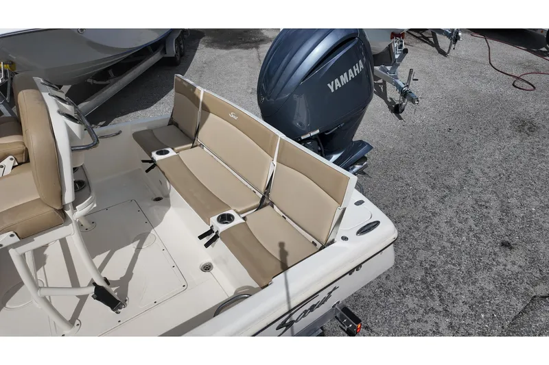 Slide: The Image of 2021 Scout 251 XSS boat interior with Yamaha engine, featuring beige seating and cup holders. - 12