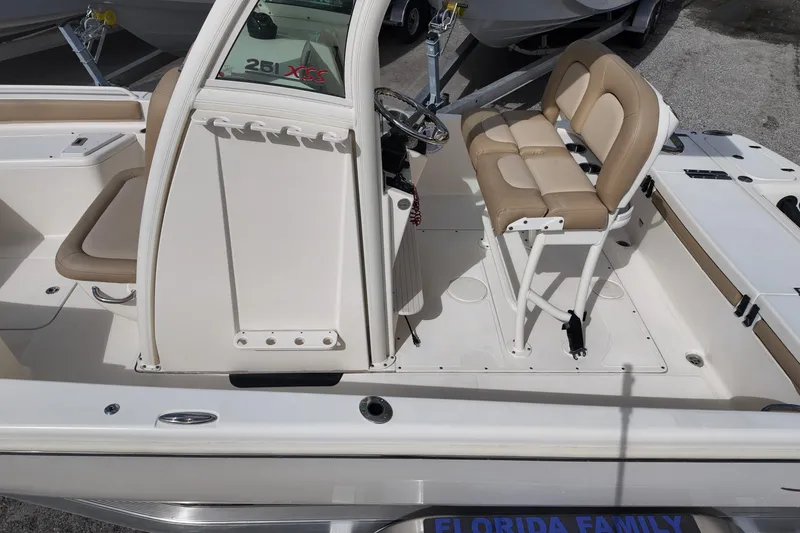 Slide: The Image of 2021 Scout 251 XSS boat interior with beige seating and steering console. - 15