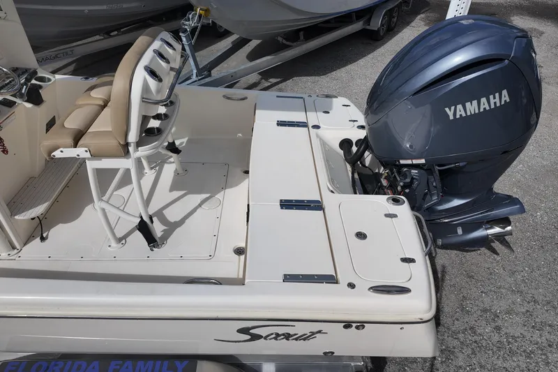 Slide: The Image of 2021 Scout 251 XSS boat with Yamaha outboard motor, featuring beige seating and fishing rod holders. - 16