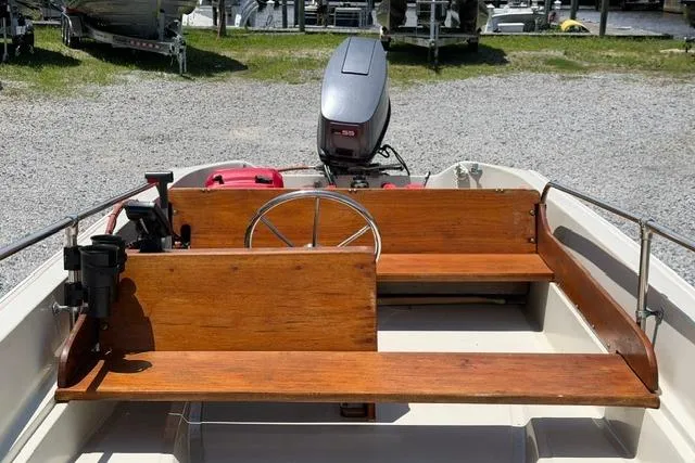 Slide: The Image of 1984 Boston Whaler 150 Sport boat interior with wooden seating and steering wheel. - 10
