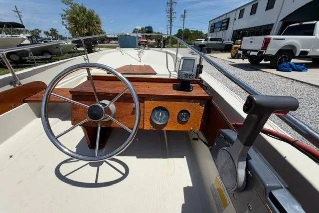Slide: The Image of 1984 Boston Whaler 150 Sport boat dashboard with steering wheel and gauges. - 11