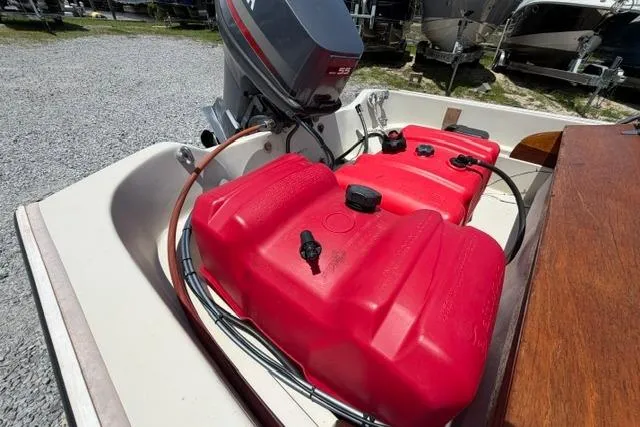 Slide: The Image of 1984 Boston Whaler 150 Sport boat with red fuel tanks and outboard motor. - 13
