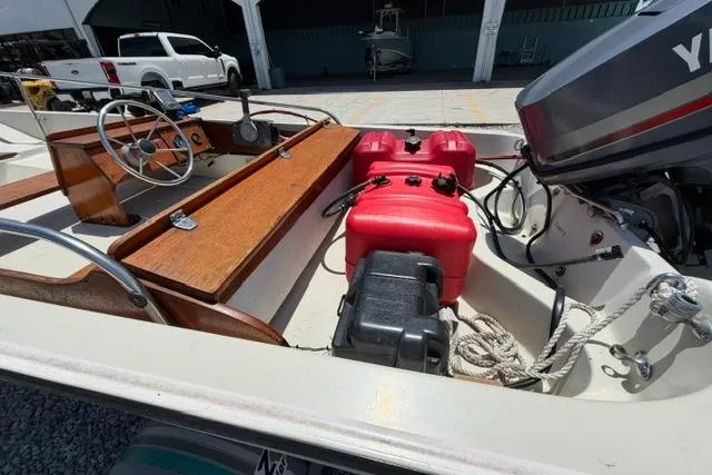 Slide: The Image of 1984 Boston Whaler 150 Sport boat interior with steering wheel, red fuel tank, and Yamaha outboard motor. - 14