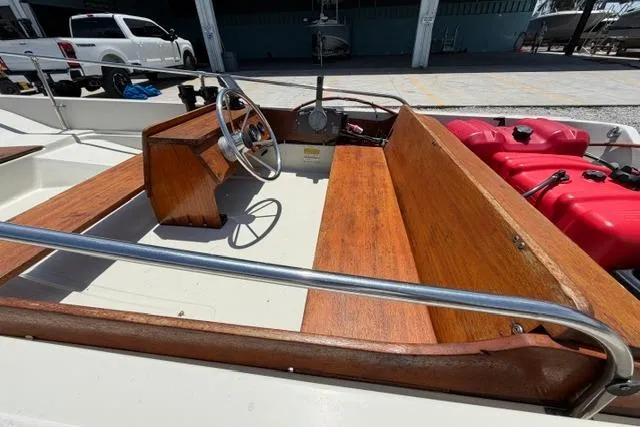 Slide: The Image of 1984 Boston Whaler 150 Sport boat interior with wooden seating and steering wheel. - 15