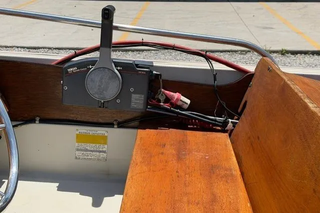 Slide: The Image of 1984 Boston Whaler 150 Sport interior with wooden seating and Yamaha control panel. - 17