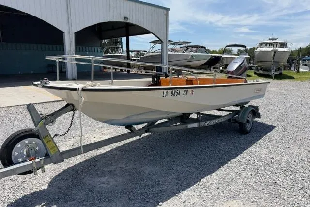 Slide: The Image of 1984 Boston Whaler 150 Sport boat on trailer, parked outdoors near a marina. - 6