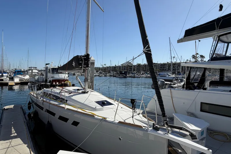 Slide: The Image of 2024 Jeanneau Sun Odyssey 349 sailboat docked in a marina under clear blue skies. - 16