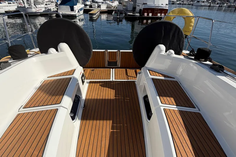 Slide: The Image of 2024 Jeanneau Sun Odyssey 349 sailboat cockpit with teak flooring, docked at marina. - 25