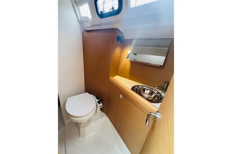 Slide: The Image of 2024 Jeanneau Sun Odyssey 349 yacht bathroom with toilet, sink, and mirror. - 71