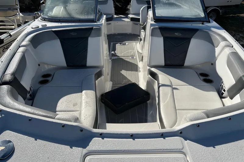 Slide: The Image of 2021 Chaparral 230 Suncoast boat interior with cushioned seating and cup holders. - 21