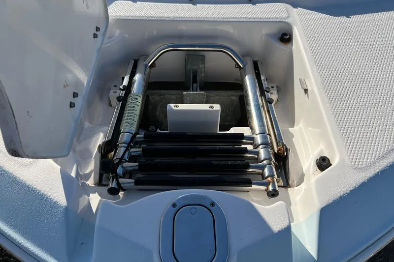 Slide: The Image of 2021 Chaparral 230 Suncoast boat ladder compartment, showcasing stainless steel hardware. - 23