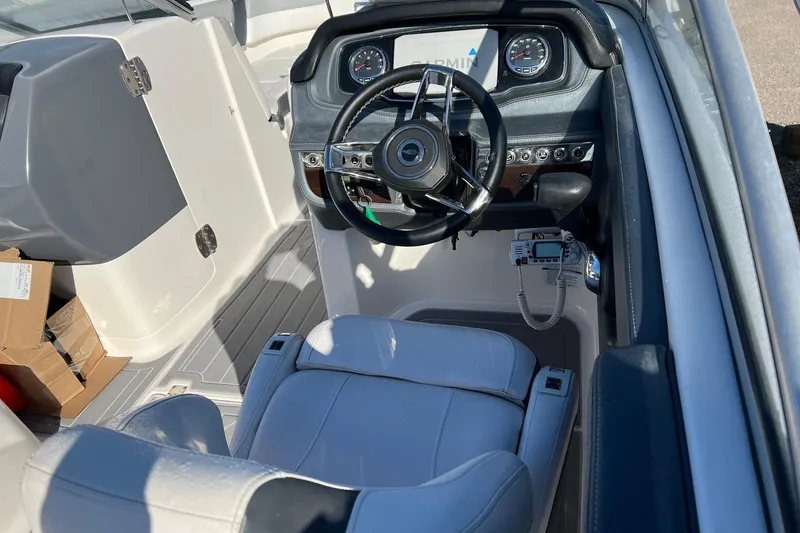 Slide: The Image of 2021 Chaparral 230 Suncoast boat cockpit with steering wheel and control panel. - 29