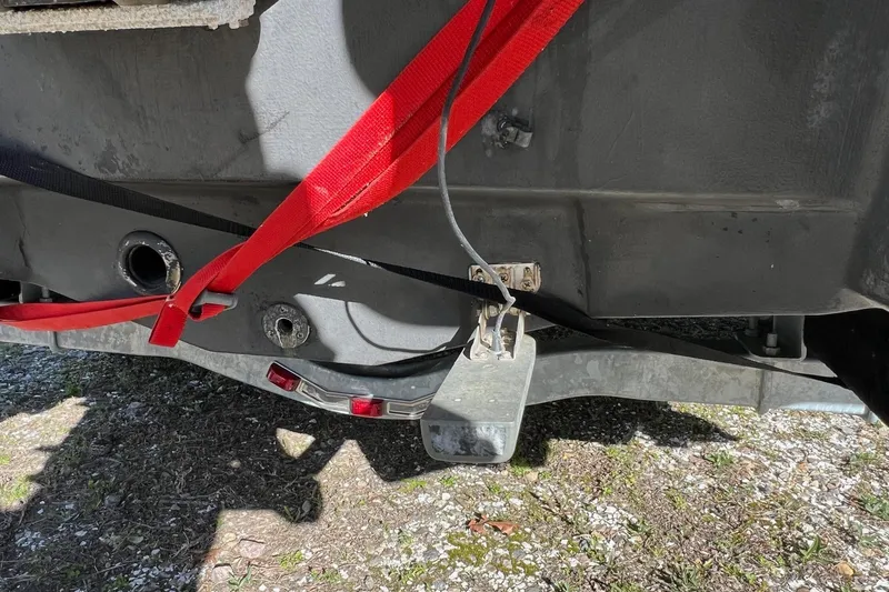 Slide: The Image of Rear view of 2021 Chaparral 230 Suncoast boat with red straps and trailer. - 38