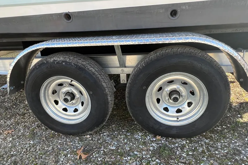 Slide: The Image of Trailer wheels of a 2021 Chaparral 230 Suncoast boat on gravel surface. - 40