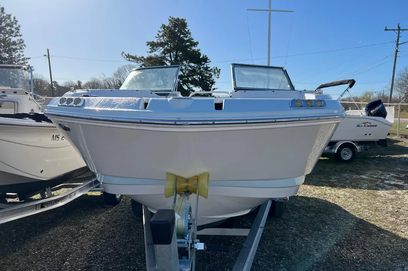 Slide: The Image of 2021 Chaparral 230 Suncoast boat on trailer, parked outdoors under clear sky. - 5